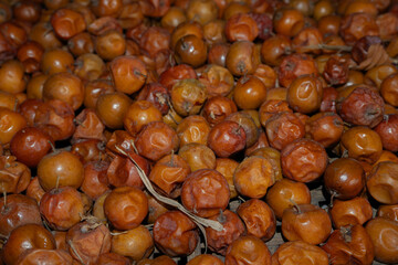 Dark brown jujubes pile up on the container and can be used as a background for commercial use.