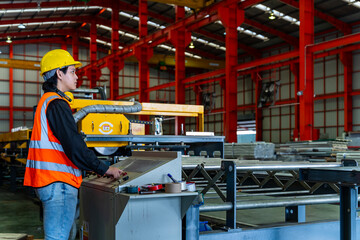 Engineering technician worker is operating the machine inside factory using touch screen computer...