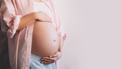 Closeup beautiful pregnant woman belly with her hands. Pregnancy, maternity, preparation and expectation concept. - obrazy, fototapety, plakaty