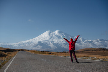 a girl does exercises with a view of Elbrus