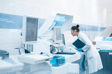 A laboratory technician in a lab coat performs a series of tests on a chemical analyzer in a bio laboratory. impersonal unrecognizable laboratory
blurred fuzzy background shot through glass with space