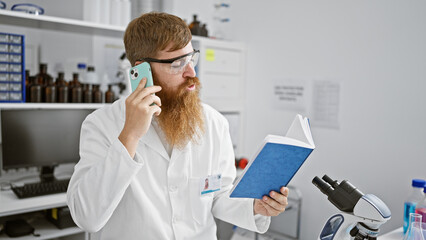 Chatty young redhead guy, a scientist engrossed in reading a book, takes a quick break indoors his...