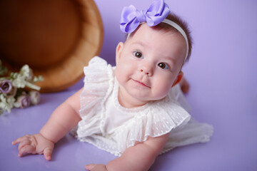 baby girl posing and smiling purple background