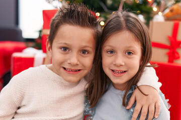Adorable boy and girl hugging each other celebrating christmas at home