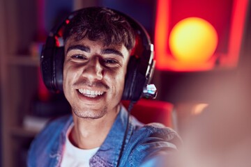 Young hispanic man streamer smiling confident make selfie by camera at gaming room