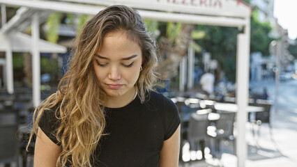 Young, beautiful hispanic woman casts a serious expression, standing on a sunny coffee shop...