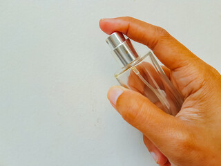female hand with perfume on a white background