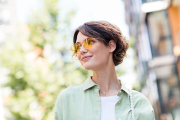 Photo of shiny positive girl dressed trendy outfit enjoying sunny weather walk alone in peace...