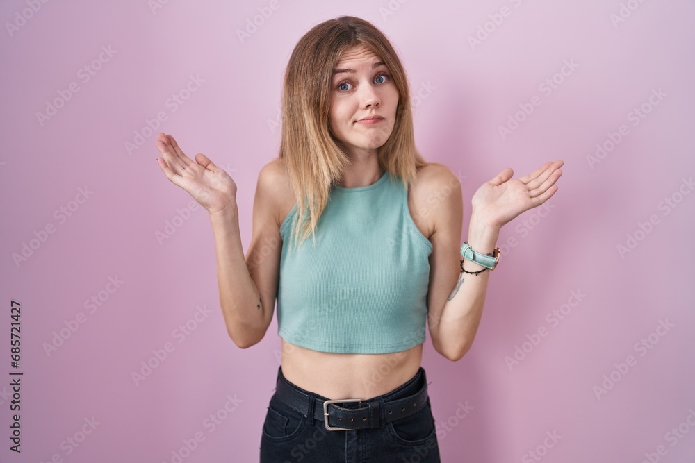 Canvas Prints blonde caucasian woman standing over pink background clueless and confused expression with arms and 