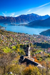 Lake Como photographed from Ossuccio, showing mountains, Bellagio, the town of Ossuccio, and the Church of the Madonna del Socco, in autumn.
