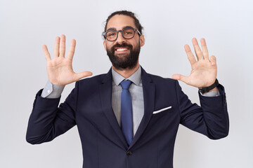 Hispanic man with beard wearing suit and tie showing and pointing up with fingers number nine while smiling confident and happy.