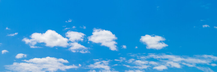 Fototapeta premium White curly clouds in the blue sky in sunny weather