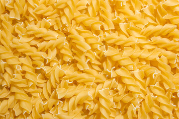 Uncooked Fusilli Pasta: A Culinary Canvas of Spiral Macaroni, Creating a Lively and Textured Background for Gourmet Cooking. Dry Pasta. Raw Macaroni - Top View, Flat Lay