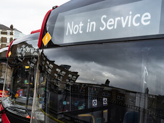 Line of red buses with out of service sign