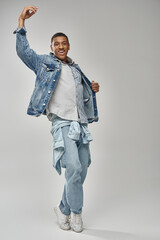 Fototapeta premium attractive emotional african american man in stylish denim outfit gesturing lively, fashion concept