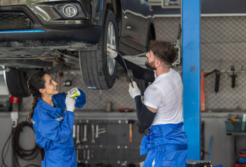 Car technicians analyze, fix wheel issues in garage, using precise tools for optimal alignment.