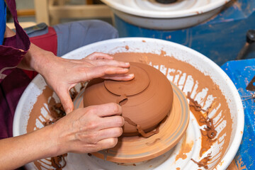 A piece of ceramic taking shape on the wheel by expert hands.