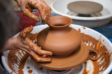 Fototapeta na wymiar A piece of ceramic taking shape on the wheel by expert hands.