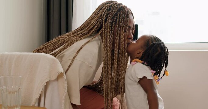 young African mother kiss and play with her child with funny dreads in morning bedroom. Concept of children, baby,parenthood,childhood,life,maternity,motherhood relationship close up shot slow motion