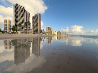 Apartment Buildings are mirroring at the Beach of Candeias and Piedade  early in the morning, just after sunrise. The City of Recife, Brazil is to see in the background. Jaboatao dos Guararapes