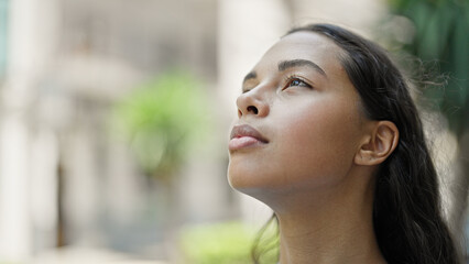 African american woman looking to the sky breathing at street