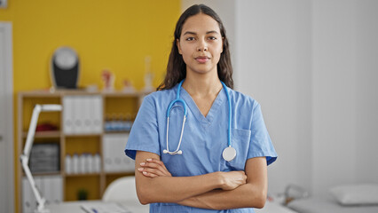 African american woman doctor standing with serious expression and arms crossed gesture at clinic