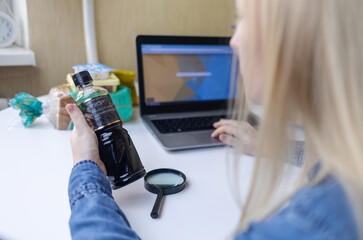 Woman reads instructions for food products at home. Checking labels on goods. Study of product...