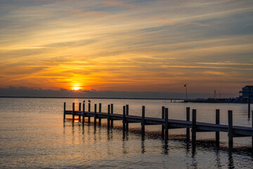 Fototapeta premium Wooden dock extending out into a Bay at Sunrise time