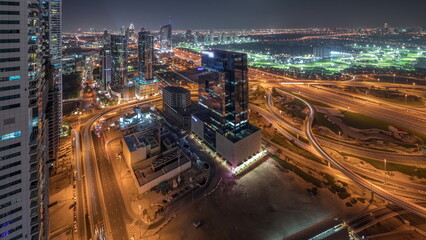 Fototapeta premium Panorama showing Dubai marina and JLT skyscrapers along Sheikh Zayed Road aerial night timelapse.