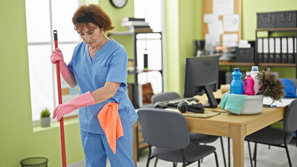 Middle age woman professional cleaner washing floor at office