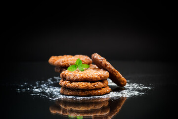 cooked sweet oatmeal cookies on black background