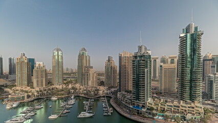 Obraz premium Panorama showing Dubai marina tallest skyscrapers and yachts in harbor aerial timelapse.