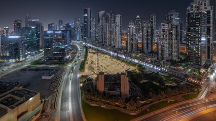 Fototapeta na wymiar Panorama showing Bay Avenue with modern towers residential development in Business Bay aerial night timelapse, Dubai