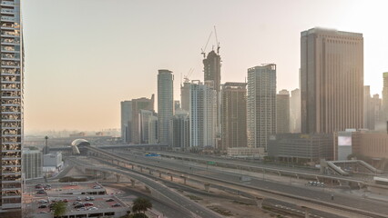 Fototapeta premium Dubai Marina skyscrapers and Sheikh Zayed road with metro railway aerial all day timelapse, United Arab Emirates