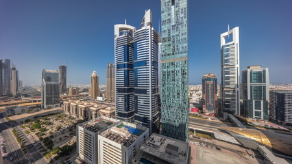 Naklejka premium Aerial view of Dubai International Financial District with many skyscrapers all day timelapse.
