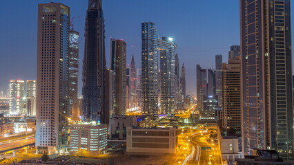 Many towers and skyscrapers with traffic on streets in Dubai Downtown and financial district night...
