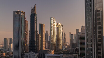 Many towers and skyscrapers with traffic on streets in Dubai Downtown and financial district morning timelapse.