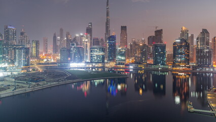 Aerial view to Dubai Business Bay and Downtown with the various skyscrapers and towers night to day timelapse