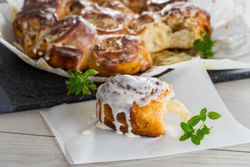 cooked baked sweet cinnabon with cream in baking paper .