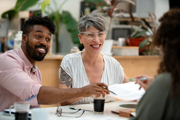 African American businessman discussing over paperwork with coworkers