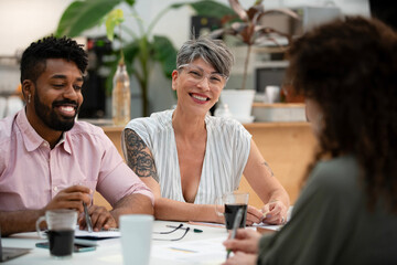 Female graphic designer looking at the camera while sitting at table