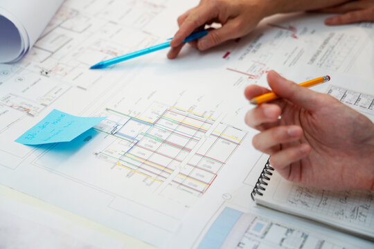 Cropped image of architects hands pointing on blueprint