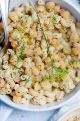 Scallop with creamy pasta in a white frying pan.top view
