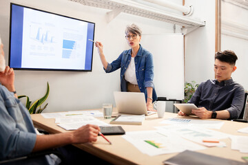 Female project manager discussing over business charts with coworker