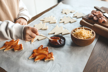 Child making pizza in the shape of a Christmas tree, activity idea