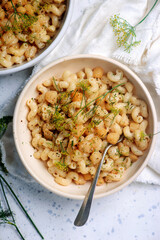 Scallop with creamy pasta in a white frying pan.top view