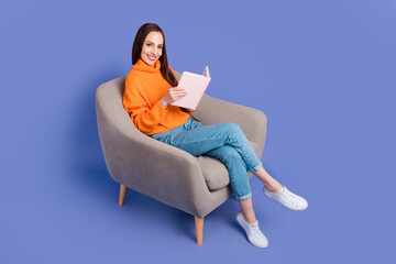 Fototapeta na wymiar Full body length photo of smiling young happy woman spend her weekend at home just reading the book isolated on violet color background