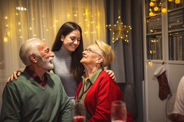 Fototapeta premium Granddaughter with her grandparents on Christmas Eve. Family having dinner