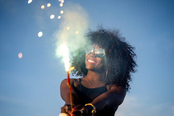 Black skinned woman using fireworks sparkler