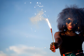 Black skinned woman using fireworks sparkler